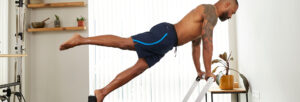 male patient stretching as part of his clinical pilates treatment in one of our clinics