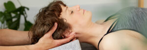 female patient receiving cranial osteopathy treatment from a practitioner