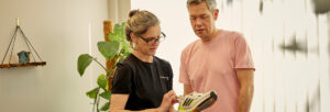 male patient in consultation with a practitioner who holds and studies a running shoe