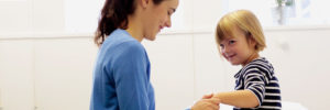 a smiling practitioner treats an equally smiling young patient
