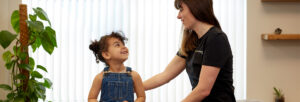 practitioner talks with a smiling young child patient