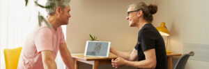 a smiling patient sits at a table in consultation with Roisin Delaney