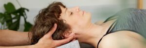 female patient receiving cranial osteopathy treatment from a practitioner