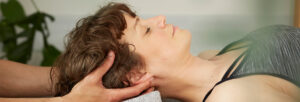 relaxed patient receiving a head massage from a practitioner